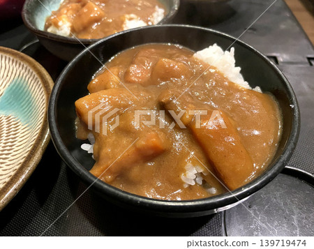 Homemade curry rice, vegetable curry, served in a black bowl. 139719474