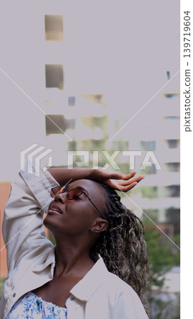 Young woman resting and relaxing while walking on city street in new eco-friendly residential complex. Relaxation and stress-free concept. Young woman resting and relaxing while walking on city street in new eco-friendly residential complex. Relaxation and stress-free concept. 139719604