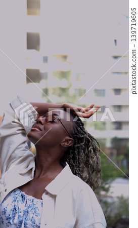 Young woman resting and relaxing while walking on city street in new eco-friendly residential complex. Relaxation and stress-free concept. Young woman resting and relaxing while walking on city street in new eco-friendly residential complex. Relaxation and stress-free concept. 139719605