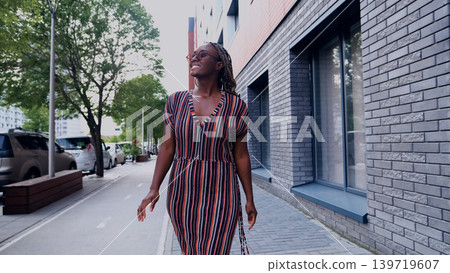 Young woman resting and relaxing while walking on city street in new eco-friendly residential complex. Relaxation and stress-free concept. Young woman resting and relaxing while walking on city street in new eco-friendly residential complex. Relaxation and stress-free concept. 139719607