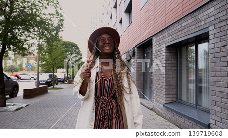 Young woman resting and relaxing while walking on city street in new eco-friendly residential complex. Relaxation and stress-free concept. Young woman resting and relaxing while walking on city street in new eco-friendly residential complex. Relaxation and stress-free concept. 139719608