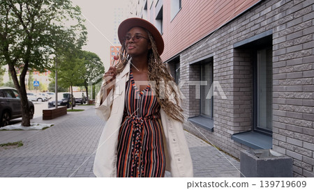 Young woman resting and relaxing while walking on city street in new eco-friendly residential complex. Relaxation and stress-free concept. Young woman resting and relaxing while walking on city street in new eco-friendly residential complex. Relaxation and stress-free concept. 139719609