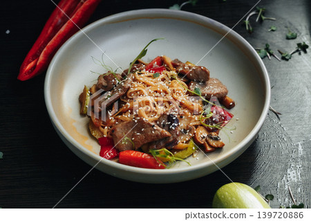 Stylish dish featuring tender beef, rice noodles, and vibrant red chili 139720886