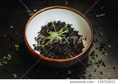 Bowl of black rice with herbs, rustic setting, healthy food theme Bowl of black rice with herbs, rustic setting, healthy food theme 139720913
