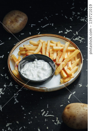 Freshly made fries with dipping sauce on dark background Freshly made fries with dipping sauce on dark background 139721019