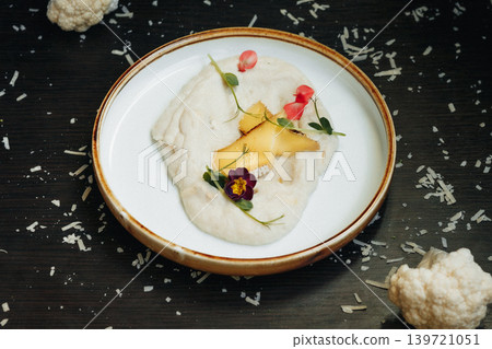 Artfully plated creamy dish with vibrant edible flowers and fruit Artfully plated creamy dish with vibrant edible flowers and fruit 139721051