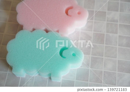 Close-up of a sheep-shaped sponge. Cute everyday item. Cleaning supplies. Material background. Close-up of a sheep-shaped sponge. Cute everyday item. Cleaning supplies. Material background. 139721183