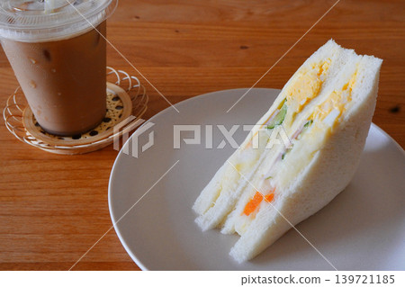 A photo of a cafe-style table setting with an egg sandwich and iced coffee for a light lunch. A photo of a cafe-style table setting with an egg sandwich and iced coffee for a light lunch. 139721185