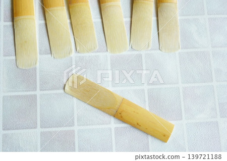 Multiple clarinet reeds and one close-up of musical instrument materials. 139721188