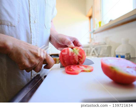 A young woman cooking tomatoes A young woman cooking tomatoes 139721634