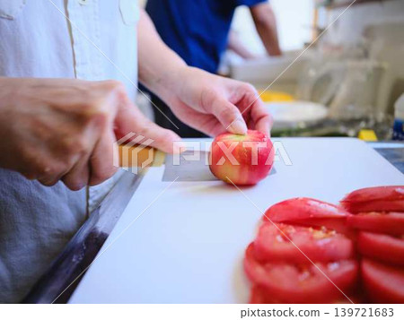A young woman cooking tomatoes A young woman cooking tomatoes 139721683