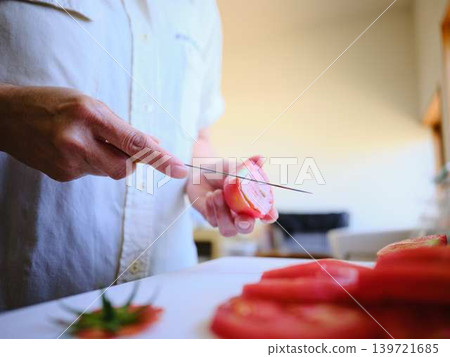 A young woman cooking tomatoes A young woman cooking tomatoes 139721685