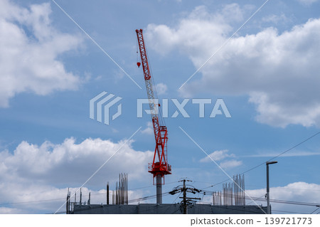 建築工地上的紅色起重機直插藍天。 建築工地上的紅色起重機直插藍天。 139721773