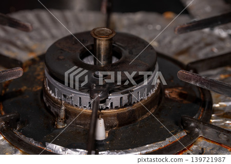 The burner part of a gas stove showing signs of use. The burner part of a gas stove showing signs of use. 139721987