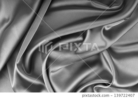 Crumpled, wrinkled gray colored glossy silk satin texture. Shiny fabric cloth with wave folds Crumpled, wrinkled gray colored glossy silk satin texture. Shiny fabric cloth with wave folds 139722407