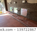 A shower and a washing area with a mirror in the bathroom of an old inn. 139722867