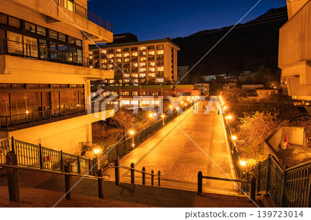 Kinugawa Onsen, Nikko City, Tochigi Prefecture: Orange streetlights illuminate the cobblestone streets at night, Fureai Bridge. 139723014