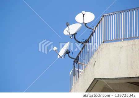 Multiple satellite dish antennas installed on the rooftop for receiving satellite broadcasts. 139723342