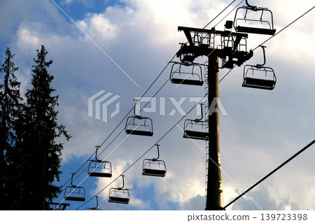 Cable car support pillar with empty chairs on cables Cable car support pillar with empty chairs on cables 139723398