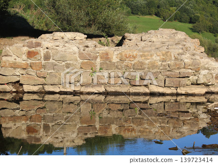 Ancient pillar of a stone bridge across a river in a mountainous area 139723414