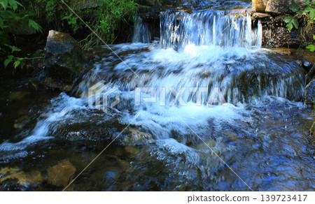 Miniature waterfalls of a small rocky river in the forest Miniature waterfalls of a small rocky river in the forest 139723417