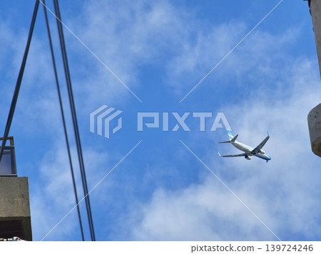 Airliner passing above concrete rooftop and dramatic clouds in Cordoba Argentina Airliner passing above concrete rooftop and dramatic clouds in Cordoba Argentina 139724246