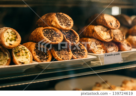 Sweet cannoli stuffed with chocolate and pistachio cream in a bakery. 139724619