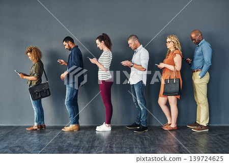 Businesspeople, job interview and waiting in line with technology or recruitment, onboarding or internet. Men, women and meeting diversity in queue or cellphone in office, human resources or hiring 139724625