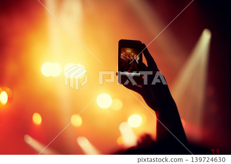 Hands, smartphone or image of performance at concert, music event or audience with flashlight in bokeh. Person, photography or online on cellphone, technology or celebration with crowd for live band Hands, smartphone or image of performance at concert, music event or audience with flashlight in bokeh. Person, photography or online on cellphone, technology or celebration with crowd for live band 139724630