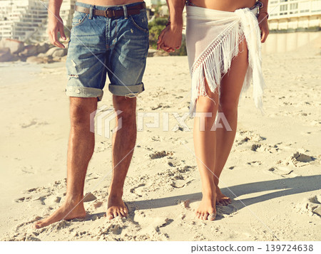 Love, closeup and couple holding hands at a beach for walking, romance and bonding in nature together. Summer, zoom and legs or people at sea for travel, holiday or vacation with support or trust Love, closeup and couple holding hands at a beach for walking, romance and bonding in nature together. Summer, zoom and legs or people at sea for travel, holiday or vacation with support or trust 139724638