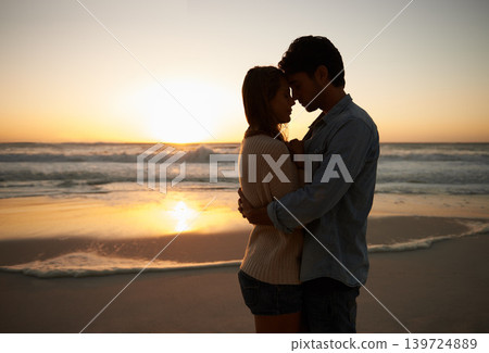 Couple, sunset and hugging on beach vacation, love and bonding on trip to ocean at dusk. People, embrace and romance on outdoor adventure at sea, peaceful environment and commitment in marriage Couple, sunset and hugging on beach vacation, love and bonding on trip to ocean at dusk. People, embrace and romance on outdoor adventure at sea, peaceful environment and commitment in marriage 139724889