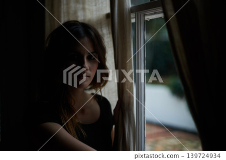 Woman, portrait and relax by window at night in dark room in stress, anxiety or mental health and lonely at home. Young female person sitting by glass at house with insomnia in neighborhood apartment Woman, portrait and relax by window at night in dark room in stress, anxiety or mental health and lonely at home. Young female person sitting by glass at house with insomnia in neighborhood apartment 139724934