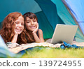 Kids, portrait and happy with laptop in tent for camping, social media or online movie with diversity in nature. Family, face and siblings or smile outdoor on grass for trip, relax or holiday fun 139724955
