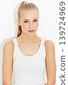 Portrait, workout and serious young woman in studio isolated on a white background. Face, healthy body and person exercise, blonde athlete training and sportswear for physical fitness in Switzerland 139724969