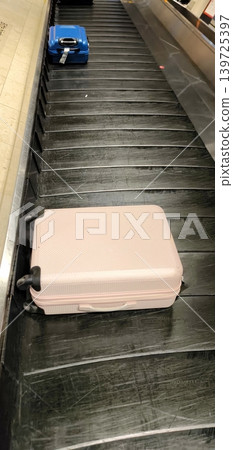 Colorful suitcases on a baggage carousel at an airport Colorful suitcases on a baggage carousel at an airport 139725397