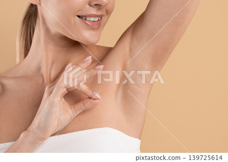 Closeup of beautiful young woman showing smooth underarm skin with approval gesture Closeup of beautiful young woman showing smooth underarm skin with approval gesture 139725614