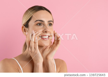 Happy young caucasian woman touching her glowing skin and smiling Happy young caucasian woman touching her glowing skin and smiling 139725643