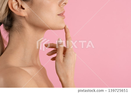 Side profile of young woman touching her chin with one finger Side profile of young woman touching her chin with one finger 139725651