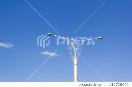 A street lamp on the background of a blue sky with white clouds A street lamp on the background of a blue sky with white clouds 139726051
