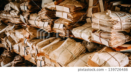 Massive chaotic pile of old yellowed paper document bundles tied with string 139726486