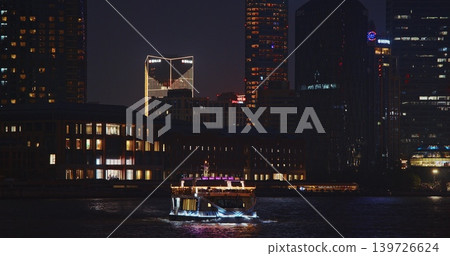 Nightscape of a Vibrant City with a Boat on the Water and Modern Buildings 139726624