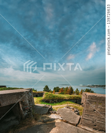 view of historic concrete bunkers and defensive structures built into the grassy landscape overlooking the Baltic Sea at the Suomenlinna fortress near Helsinki, Finland. view of historic concrete bunkers and defensive structures built into the grassy landscape overlooking the Baltic Sea at the Suomenlinna fortress near Helsinki, Finland. 139726633