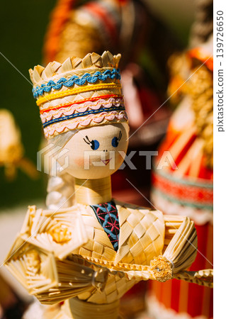 Traditional handmade woven straw doll in folk costume. 139726650