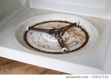 Interior surface of the microwave's bottom panel is covered in rust and rot. Recycling concept. Interior surface of the microwave's bottom panel is covered in rust and rot. Recycling concept. 139727133