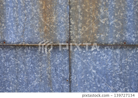 Four galvanized old steel sheets with rust spots and aged rivets. Industrial background and metallic texture with signs of corrosion. Four galvanized old steel sheets with rust spots and aged rivets. Industrial background and metallic texture with signs of corrosion. 139727134