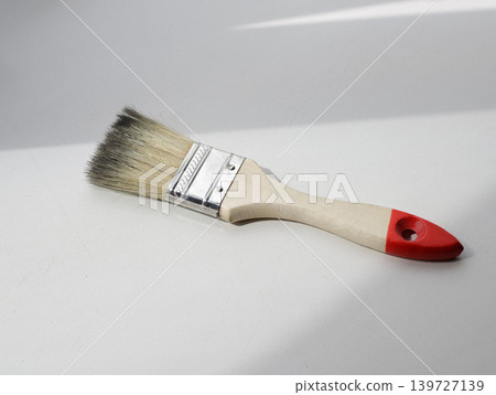 Clean wooden bristle brush on a light gray furniture panel. DIY home improvement and repair concept. Clean wooden bristle brush on a light gray furniture panel. DIY home improvement and repair concept. 139727139