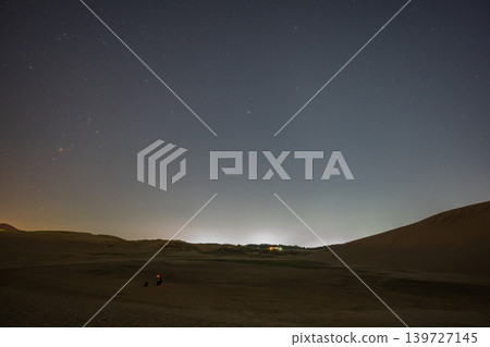 A beautiful starry sky floating above the Tottori Sand Dunes in Tottori Prefecture, Japan. A beautiful starry sky floating above the Tottori Sand Dunes in Tottori Prefecture, Japan. 139727145
