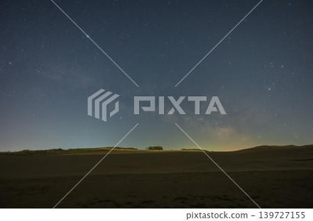 A beautiful starry sky floating above the Tottori Sand Dunes in Tottori Prefecture, Japan. A beautiful starry sky floating above the Tottori Sand Dunes in Tottori Prefecture, Japan. 139727155