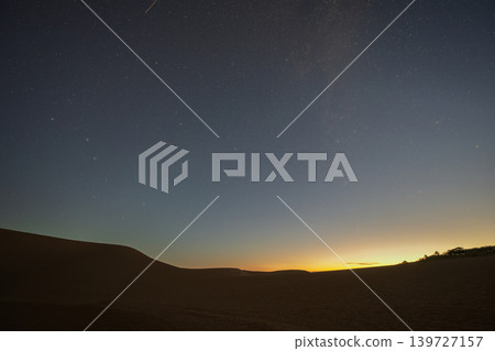 A beautiful starry sky floating above the Tottori Sand Dunes in Tottori Prefecture, Japan. A beautiful starry sky floating above the Tottori Sand Dunes in Tottori Prefecture, Japan. 139727157