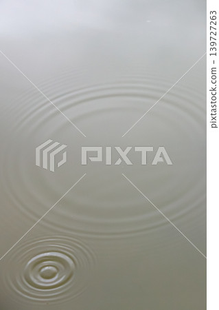 Beautiful ripples spreading gracefully across the water's surface - vertical Beautiful ripples spreading gracefully across the water's surface - vertical 139727263